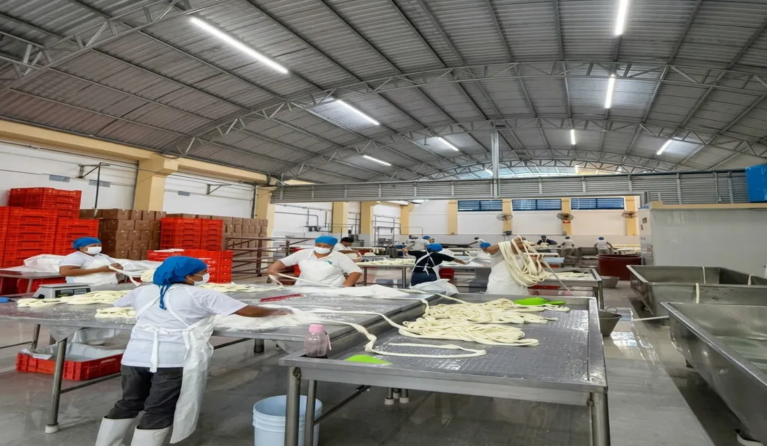 Operadores en planta de quesos con estrictos protocolos sanitarios